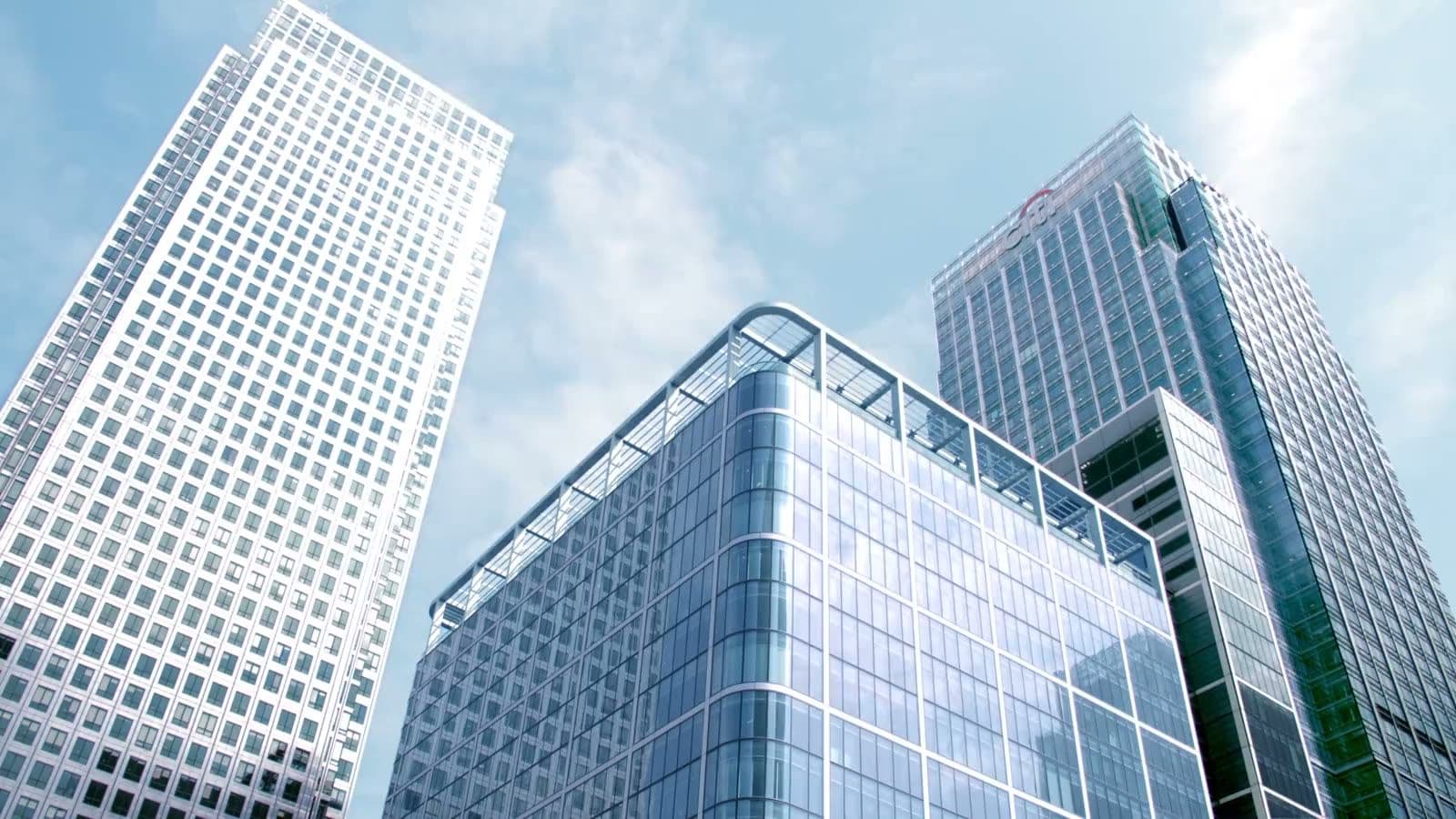 The towers of Canary Wharf seen from below against a bright sky