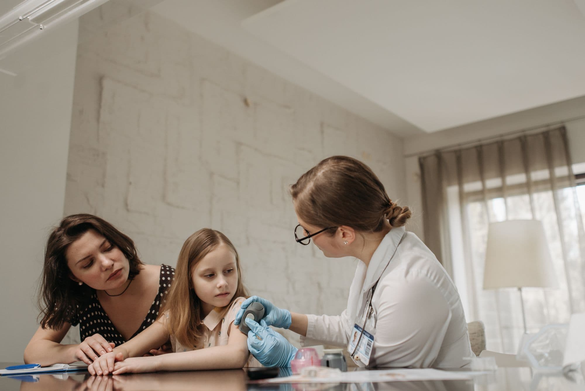 A family doctor caring for a mother and her young daughter during a private appointment