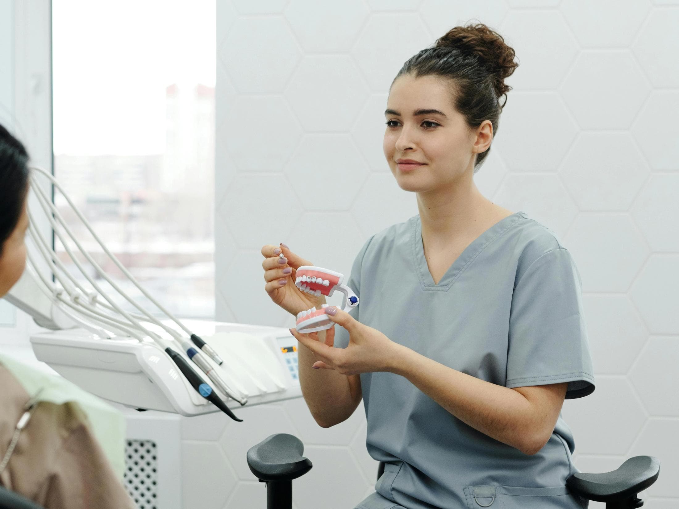 Private dental practice surgery with treatment chair, overhead light and a clinician's monitor showing patient records