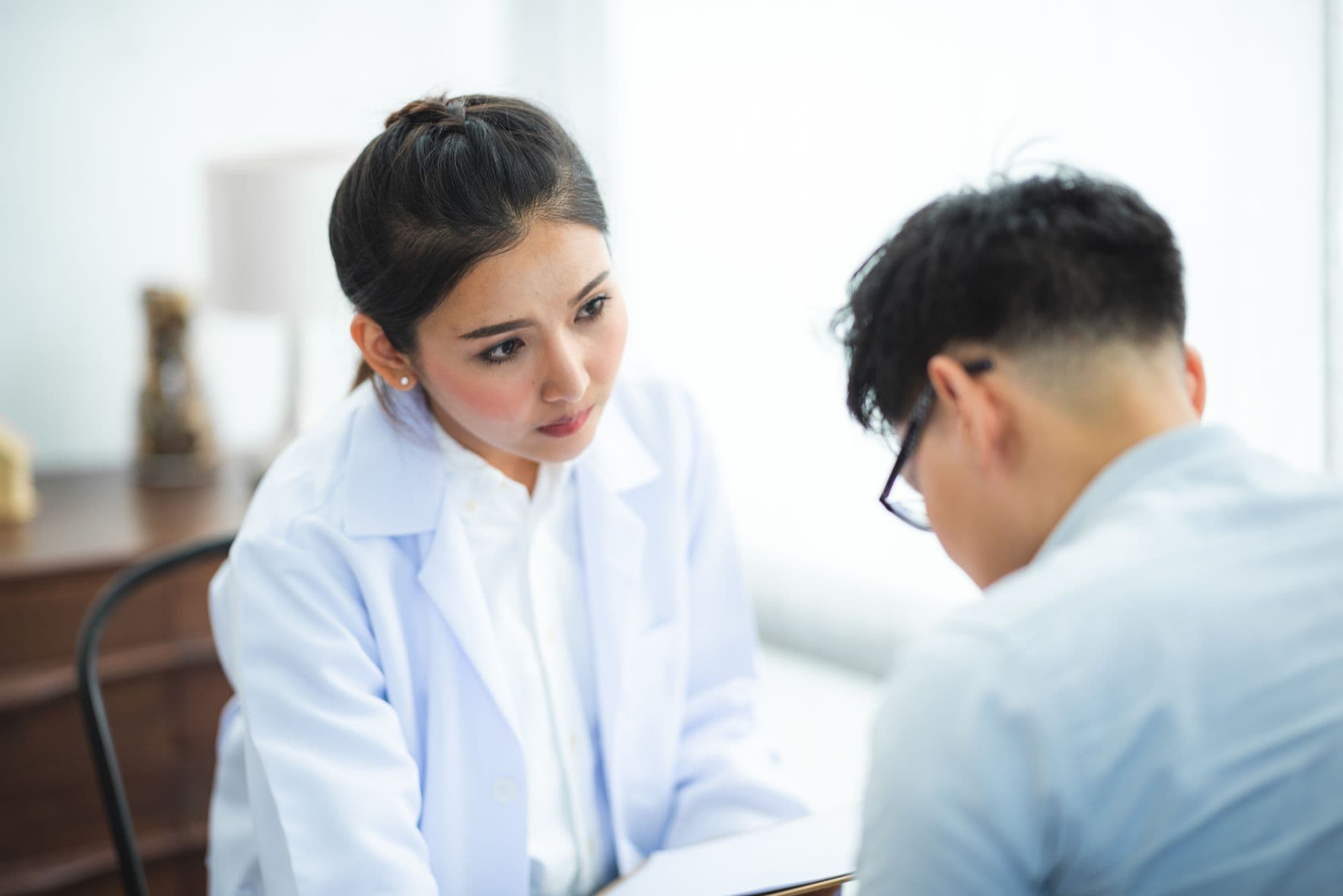 A private GP listening to a patient during a same day consultation in a bright clinic