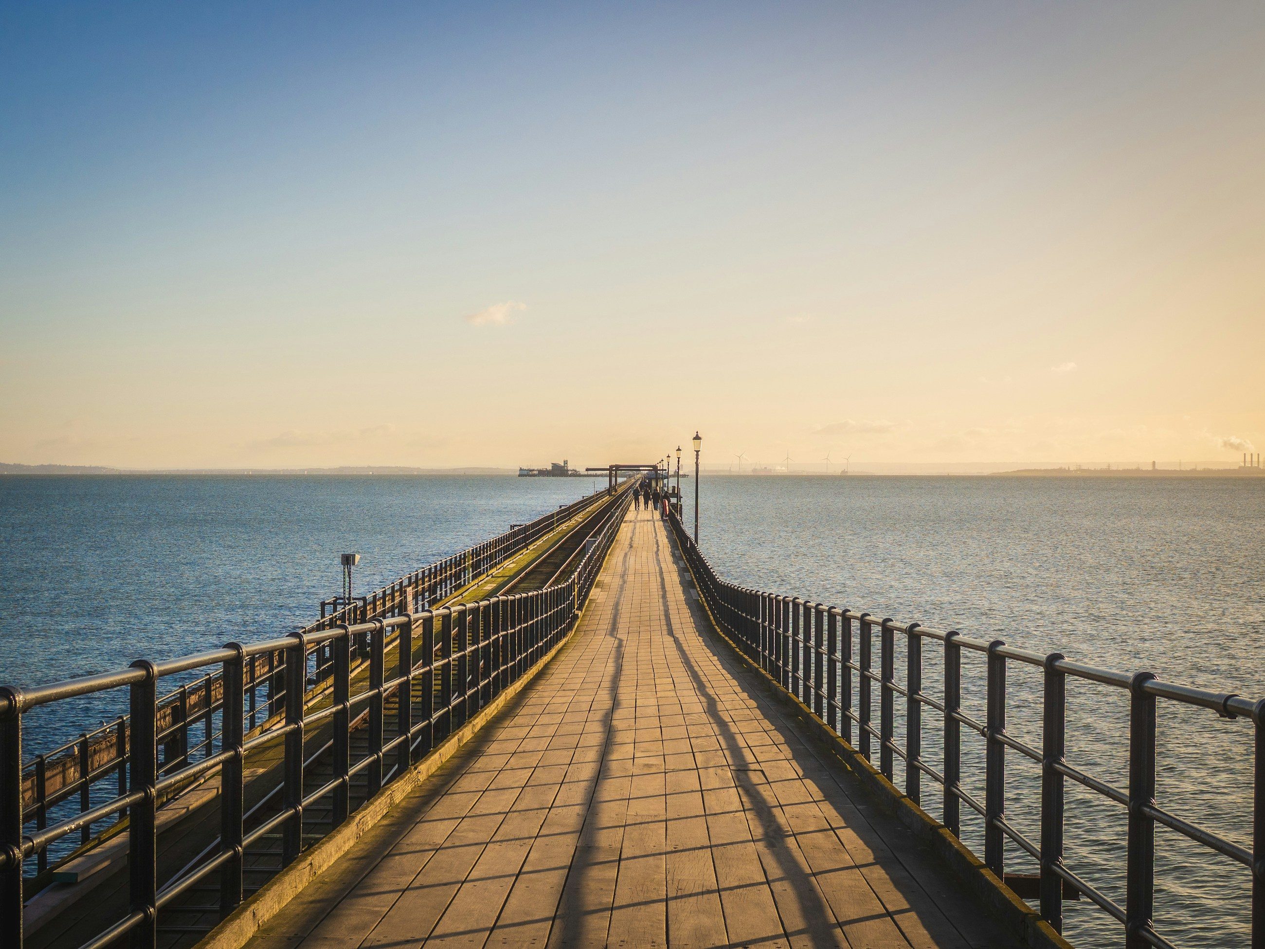 The walkway of Southend pier stretching out over the estuary in evening light