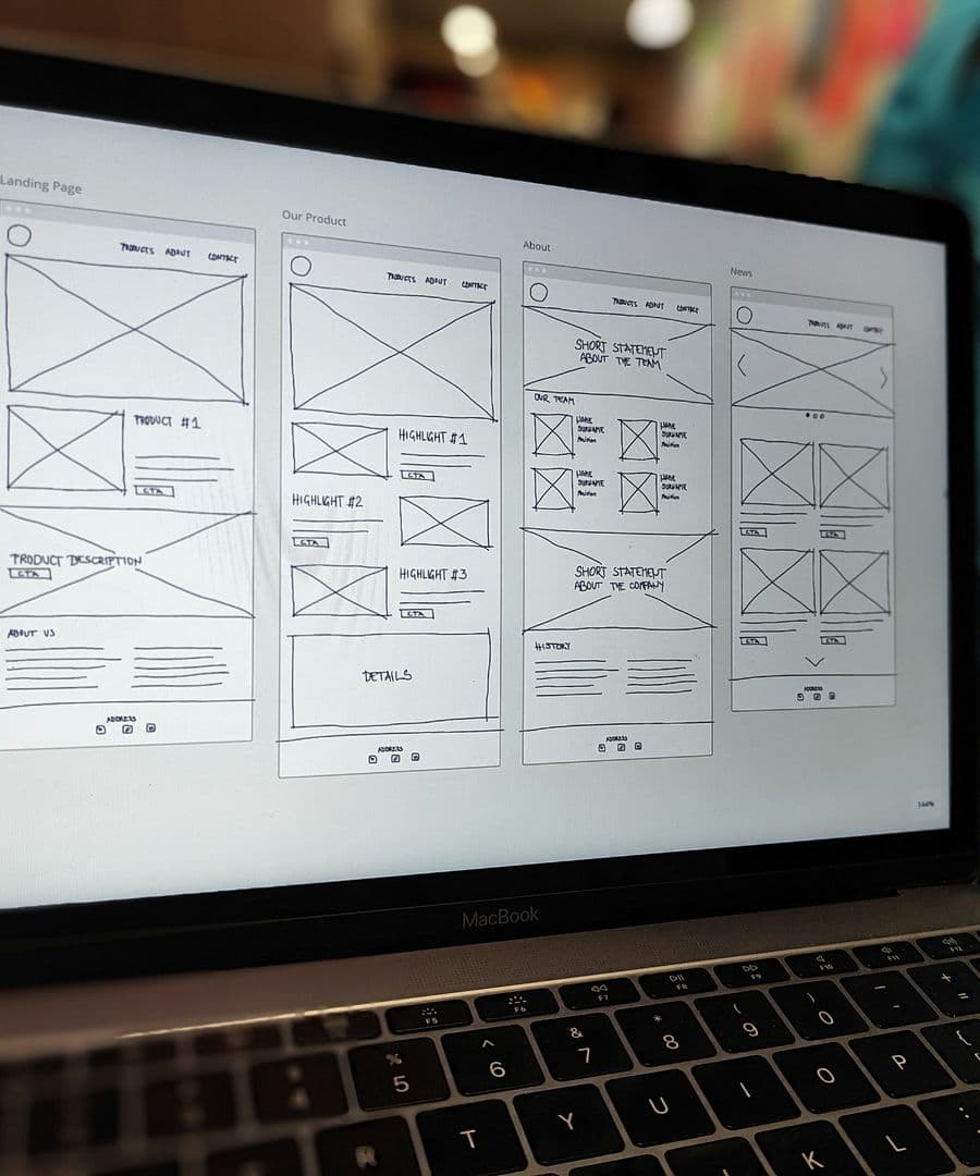 Page wireframes open on a laptop screen during the design of a website
