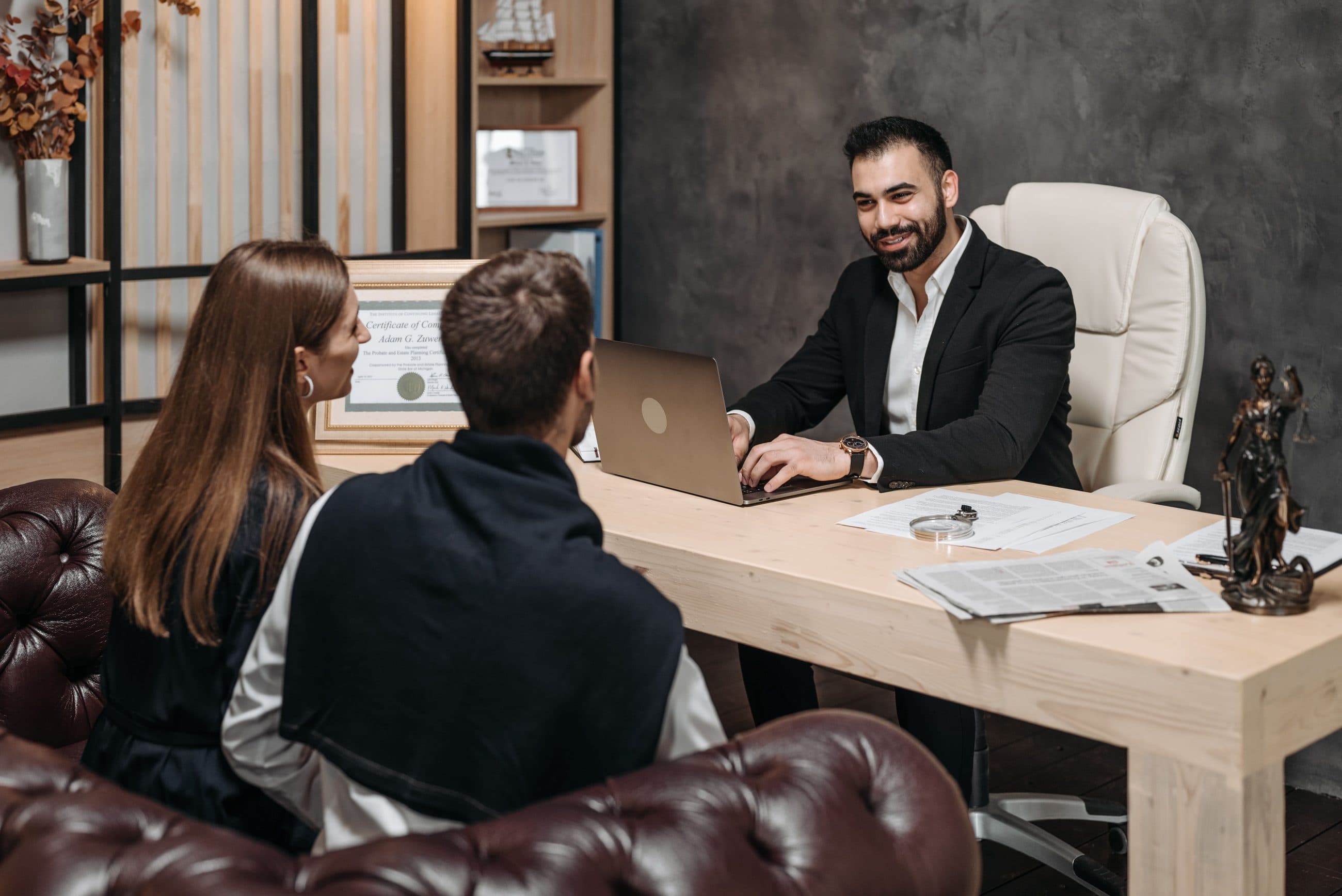 A solicitor meeting two clients at his desk