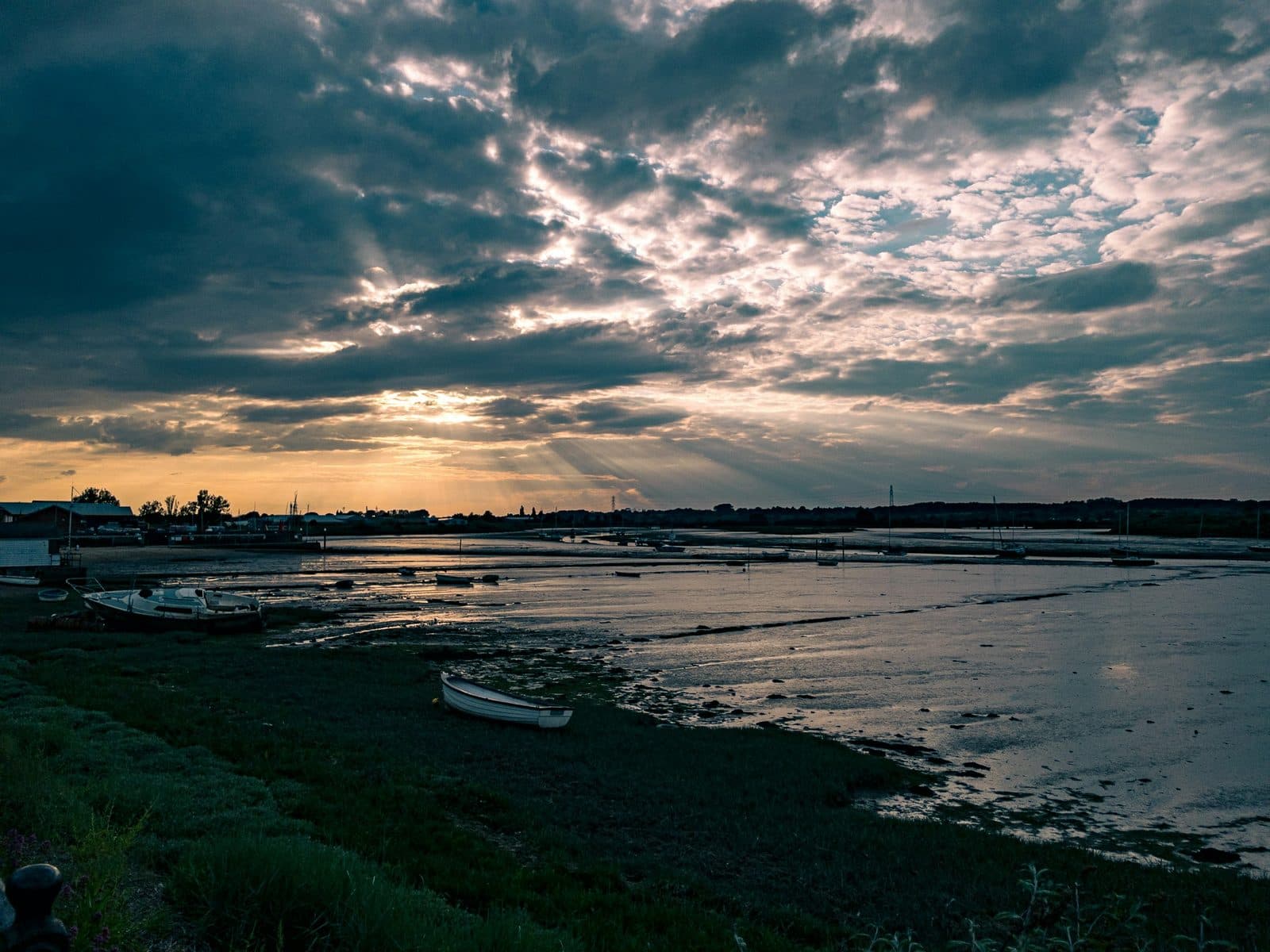Sun rays over the Stour estuary at low tide at Mistley in Essex