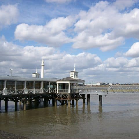 Gravesend Town Pier reaching out into the Thames under a bright sky